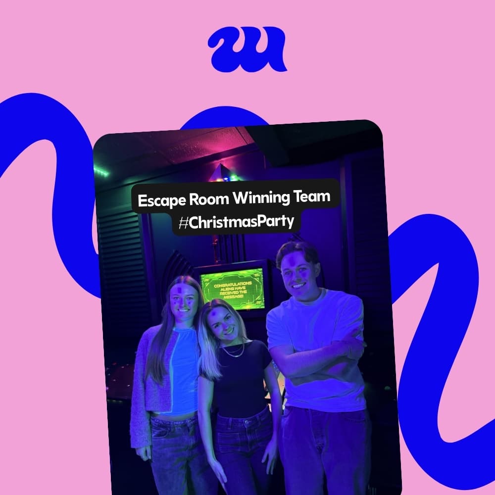 Three coworkers celebrating escape room win at Christmas party